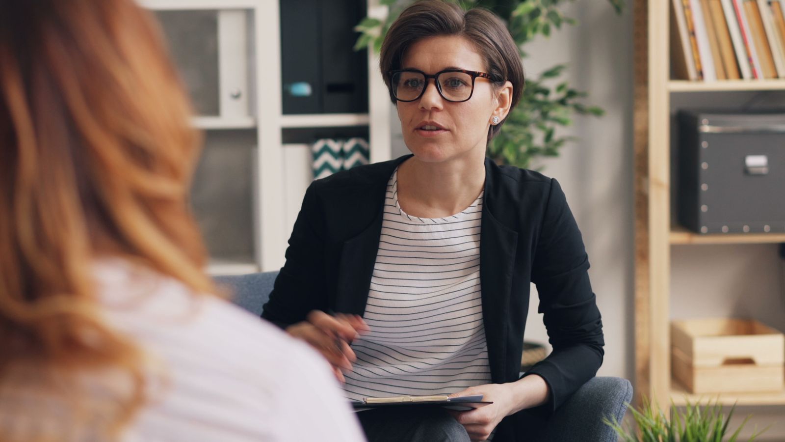 A clinician listening to a client in a calm, welcoming consultation room
